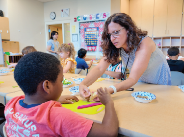 teacher helping student cook